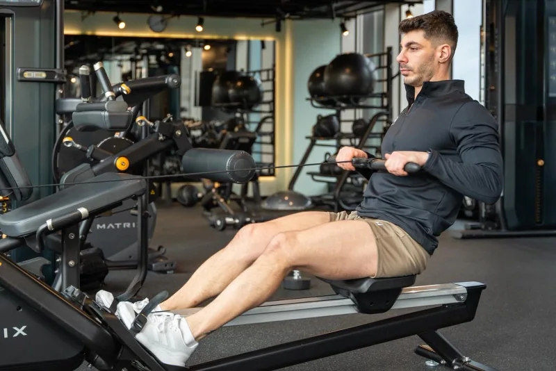 Atai performing a seated cable row in a black training top